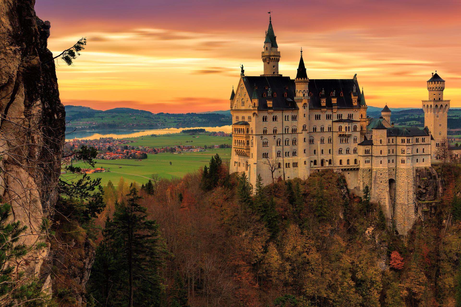 Il castello di Neuschwanstein al tramonto sopra i boschi d'autunno